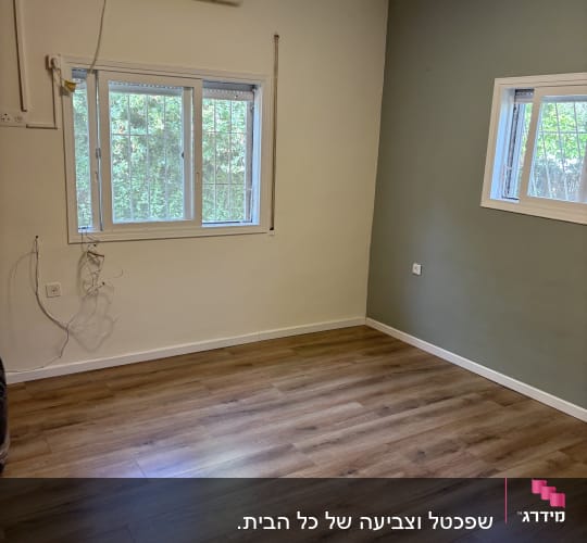 חדר ריק עם רצפת עץ וקירות צבועים